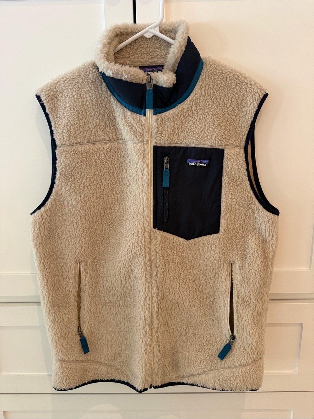 Patagonia Men’s Cream Sherpa Vest with Navy Chest Pocket and Teal Trim